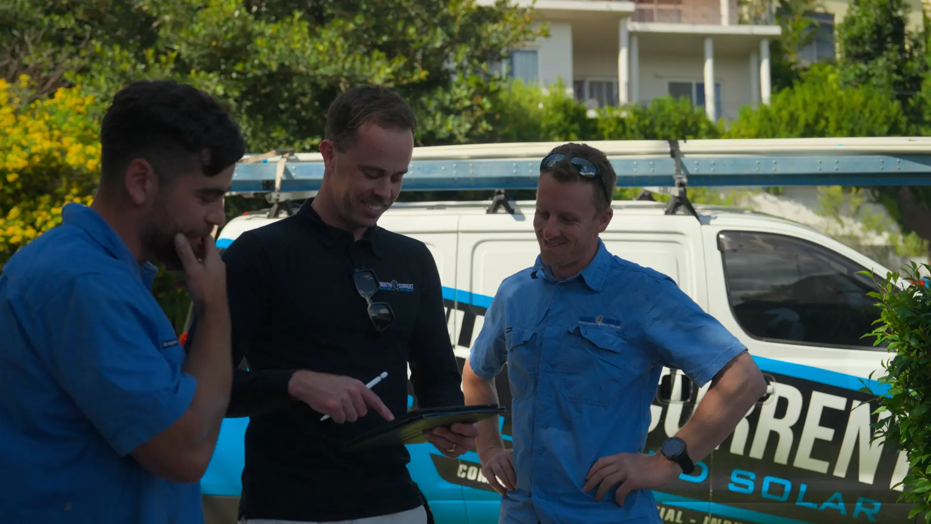 SCE team reviewing a system design on site next to the work van